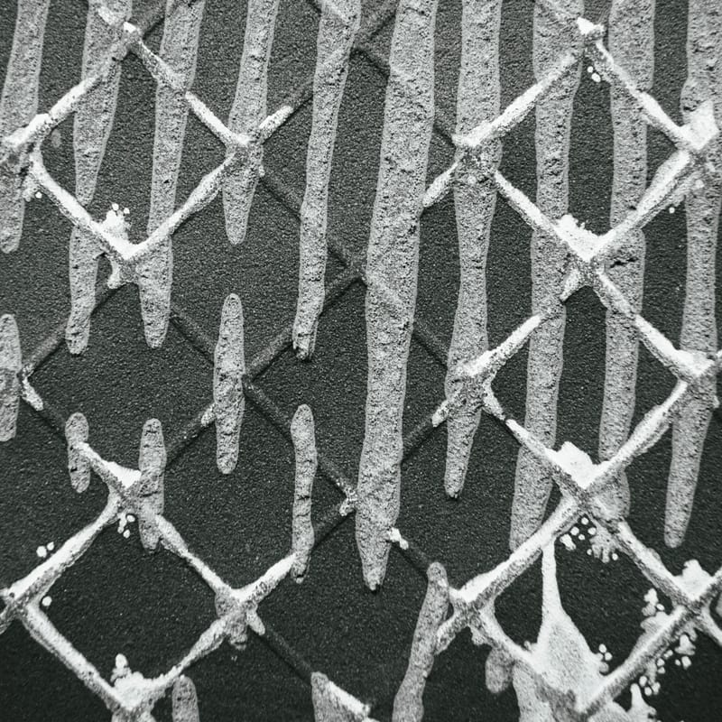 Grayscale diamond lattice pattern pressed into a textured wall surface