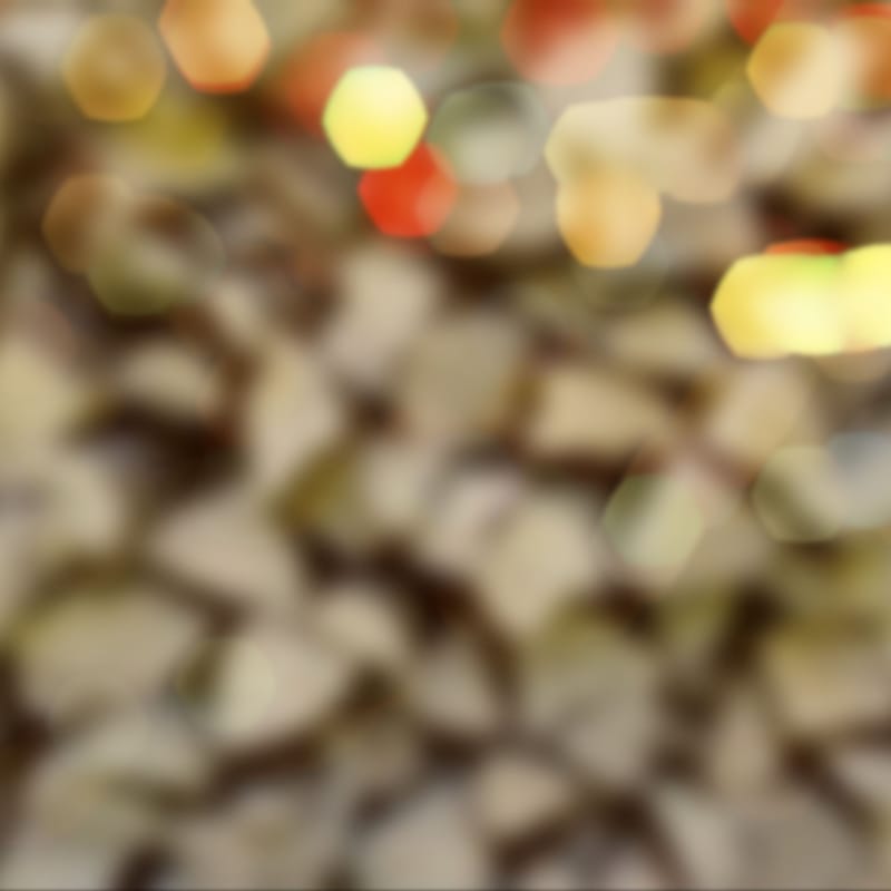 Abstract warm-toned bokeh blur with soft yellow, red, and gold light spots